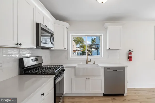 a kitchen with stainless steel appliances granite countertop a sink stove and cabinets