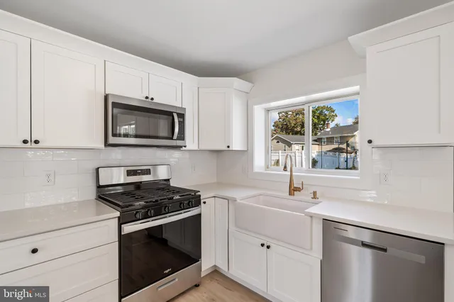 a kitchen with cabinets stainless steel appliances and sink