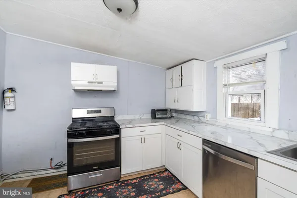 a kitchen with stainless steel appliances a stove a sink and a microwave
