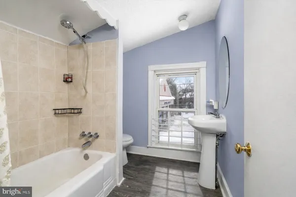 a bathroom with a bathtub a window and a shower