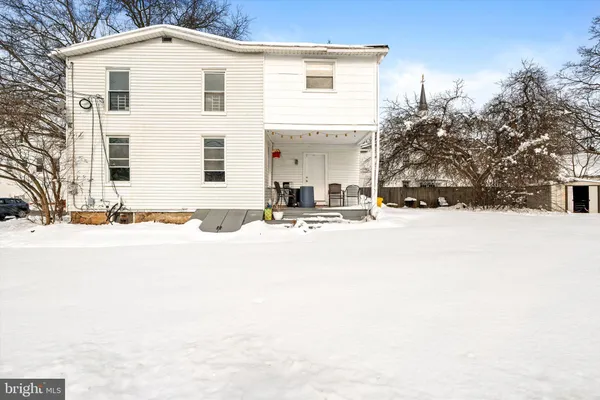 a view of a house with snow on the road