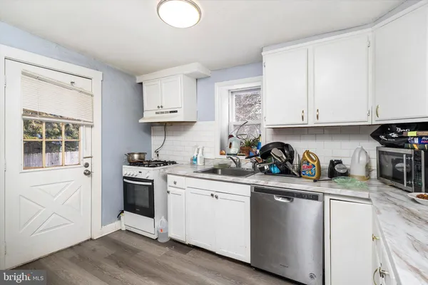 a kitchen with stainless steel appliances granite countertop a sink stove and cabinets