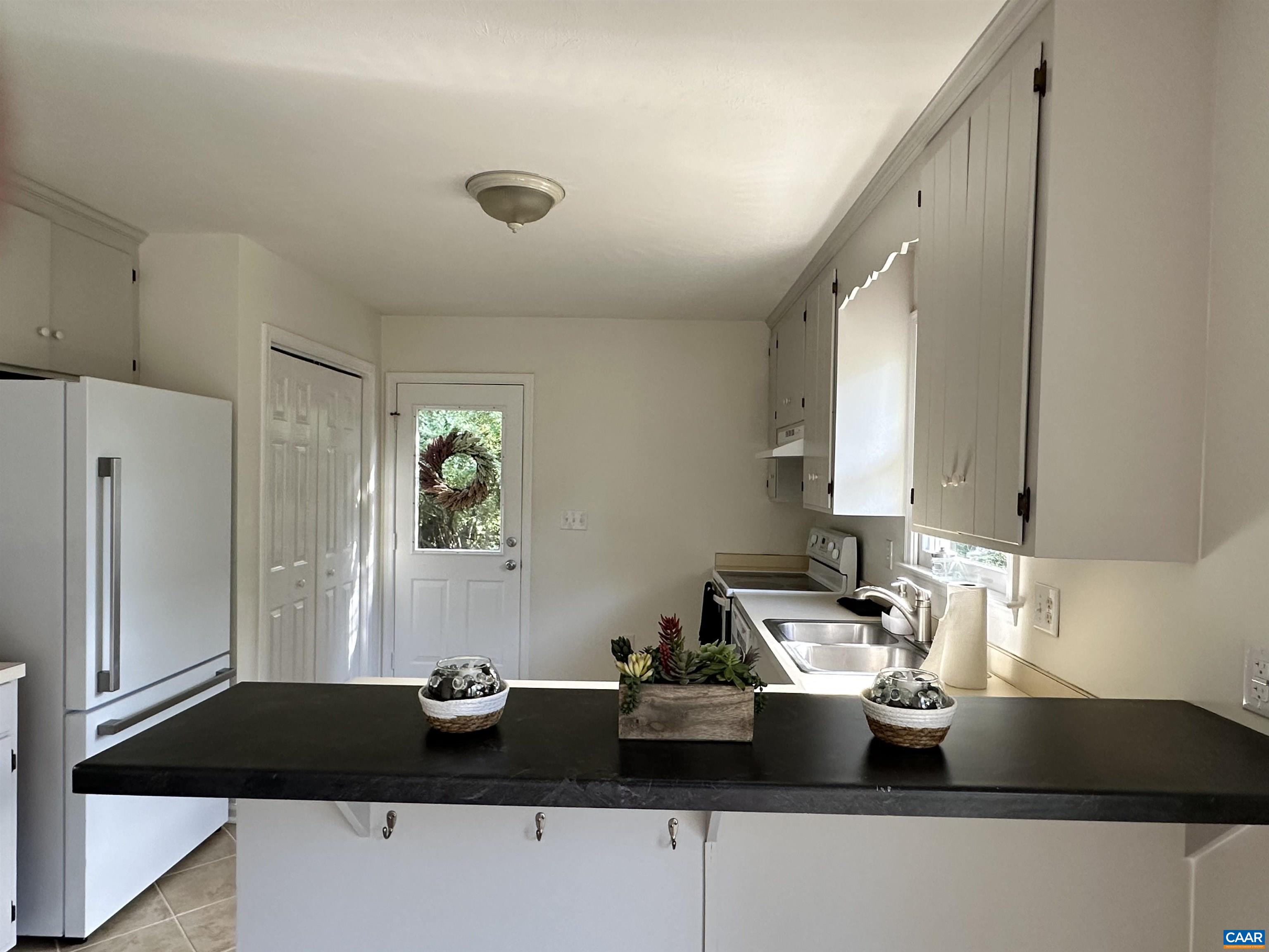 122 Petunia Road Ruckersville, VA 22968 - Photo 17 of 59 a kitchen with a sink and a refrigerator