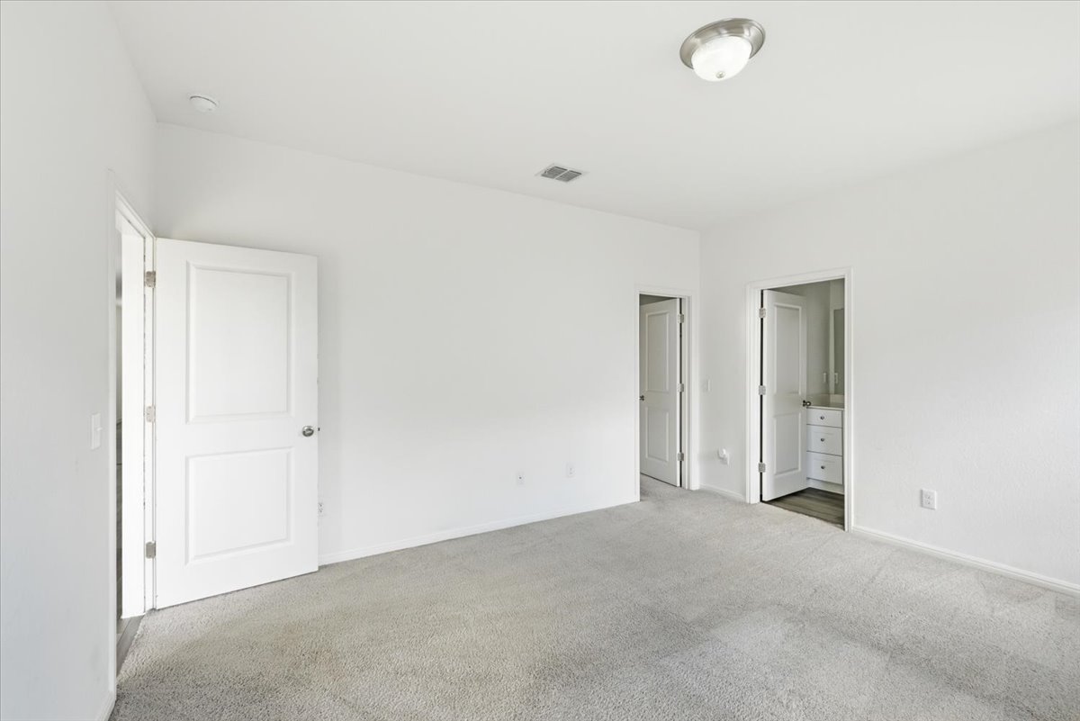 202 Peridot Pass Maxwell, TX 78656 - Photo 13 of 21 A spacious, neutral-toned bedroom awaits your personal touch with soft carpet underfoot.