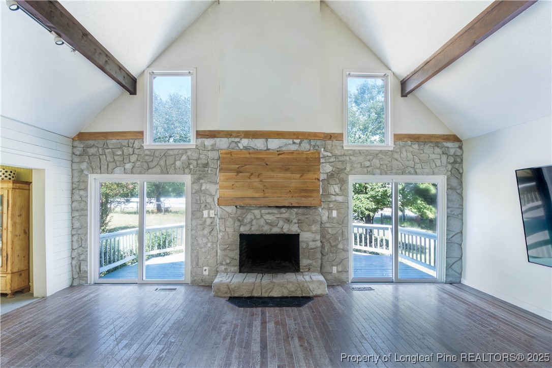 2135 Turnpike Road Raeford, NC 28376 - Photo 25 of 48 an empty room with wooden floor a fireplace and windows