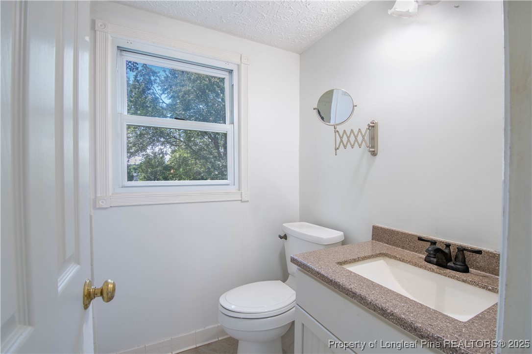 2135 Turnpike Road Raeford, NC 28376 - Photo 38 of 48 a bathroom with a granite countertop toilet and a sink