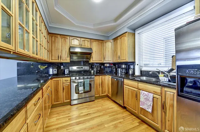 a kitchen with stainless steel appliances granite countertop a sink a stove and a refrigerator