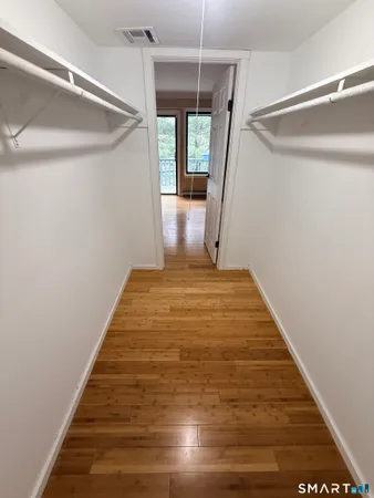 a view of a big room with wooden floor and windows
