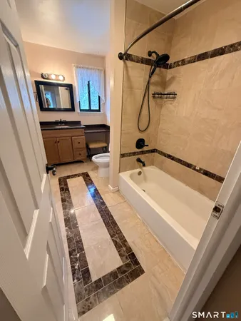 a bathroom with a tub a sink and glass door