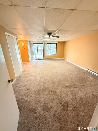 a view of a big room with wooden floor and windows
