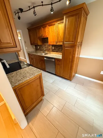 a kitchen with stainless steel appliances granite countertop a sink stove and cabinets