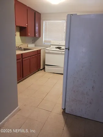 a kitchen with a sink a stove and cabinets