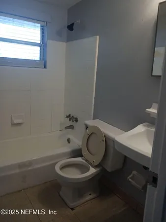 a white toilet sitting next to a bath tub