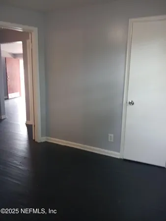 a view of a small space with wooden floor and a window