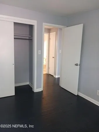an empty room with wooden floor cabinet and closet