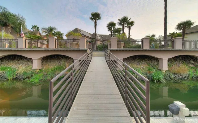 a view of a balcony with wooden floor and iron fence