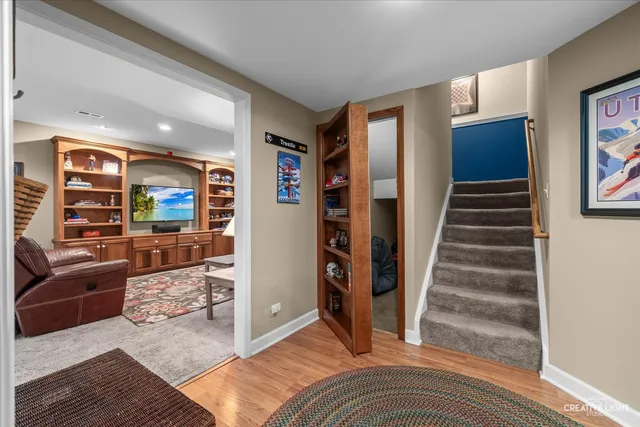 a open kitchen with stainless steel appliances granite countertop a stove top oven a sink a dining table and chairs with wooden floor