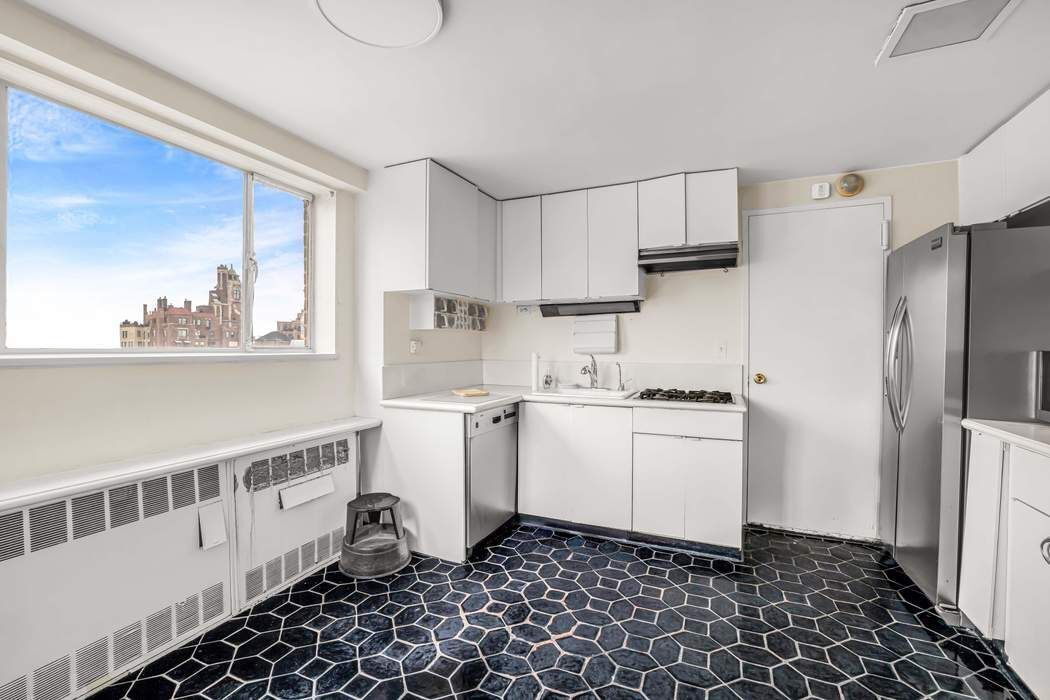 140 East 72nd Street, Unit PH Manhattan, NY 10021 - Photo 10 of 12 a kitchen with a sink a refrigerator and cabinets