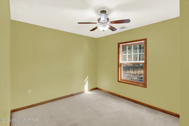 an empty room with closet and windows