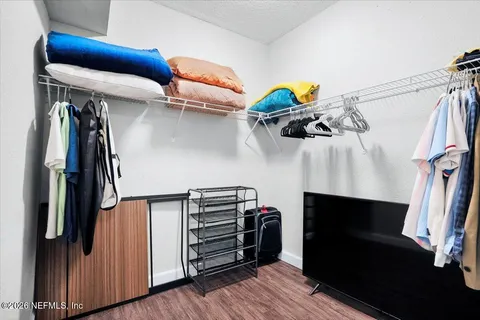 a view of walk in closet with clothes and shoes