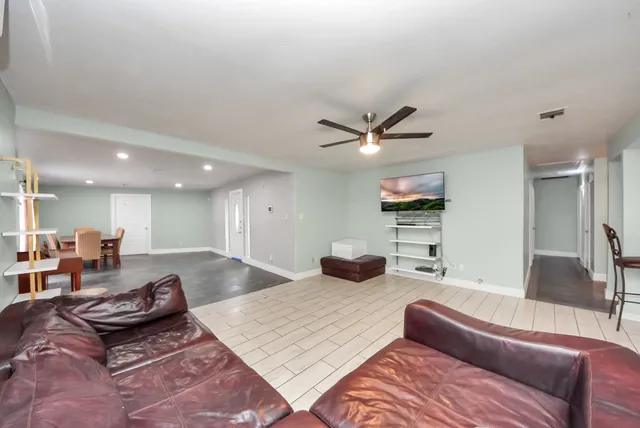 a living room with furniture and a wooden floor