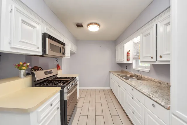a kitchen with stainless steel appliances granite countertop a sink stove and cabinets