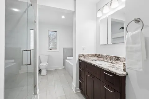 a bedroom with a bed lamp and a potted plant