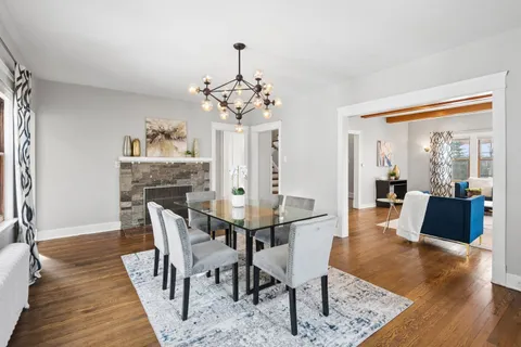 a kitchen with stainless steel appliances granite countertop a stove a sink dishwasher a refrigerator and white cabinets with wooden floor