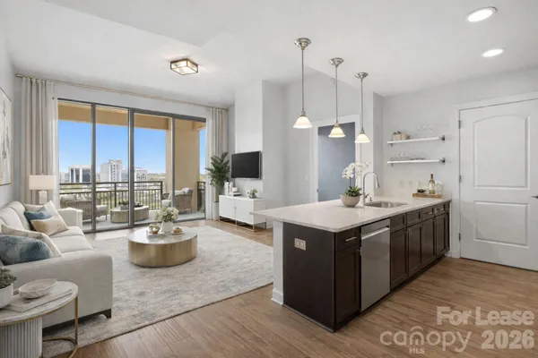 a kitchen with a stove kitchen island and couches with wooden floor