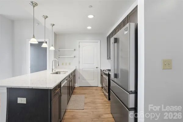 a kitchen with kitchen island sink stove and refrigerator
