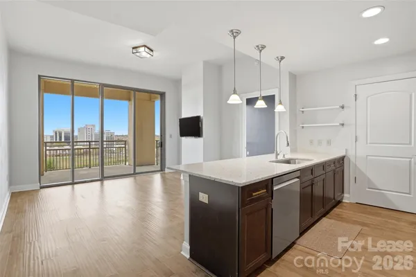 a kitchen with a stove a sink and wooden floor