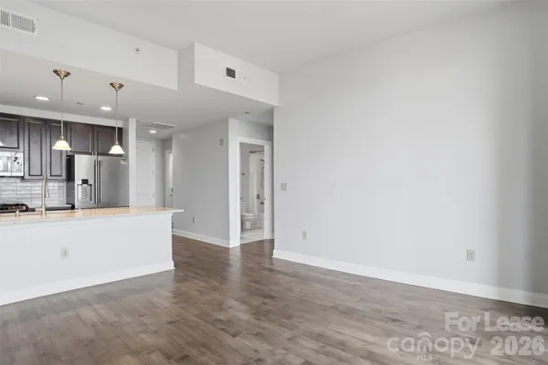 a view of a kitchen with a refrigerator and a stove top oven