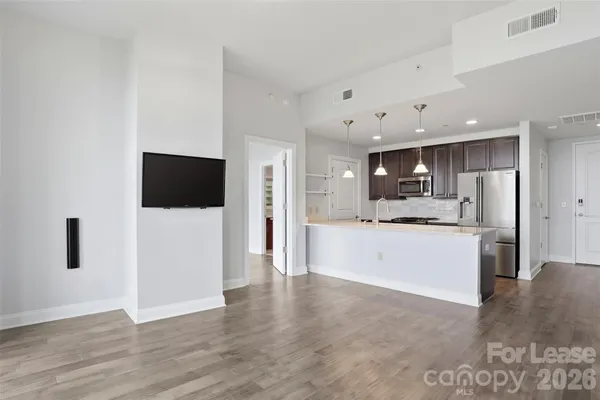 a view of a kitchen with refrigerator microwave and wooden floor