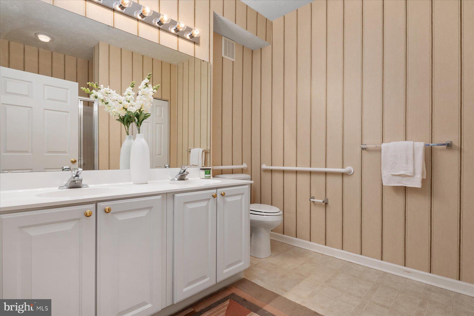 2502 Amber Orchard Court West, Unit 104 Odenton, MD 21113 - Photo 16 of 28 a bathroom with a double vanity sink and a mirror