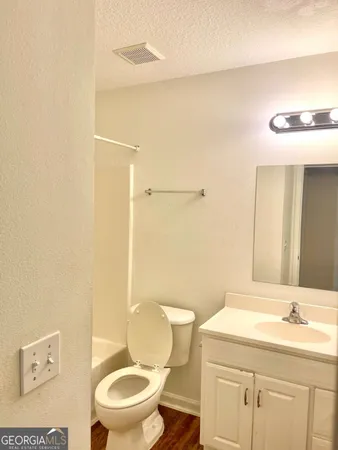 an empty room with a bathroom and a mirror