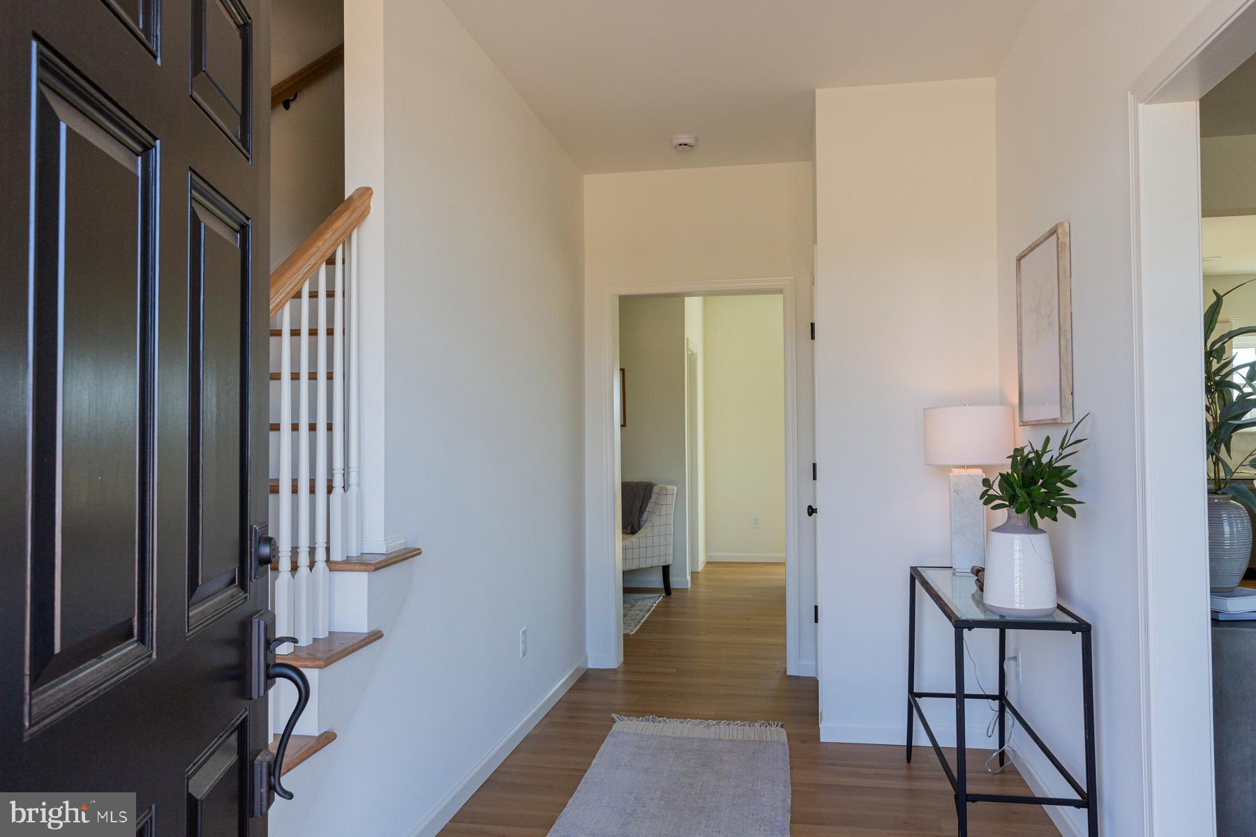 306 Wickmere Street, Unit 68 Oxford, PA 19363 - Photo 3 of 40 a view of a hallway with wooden floor and a potted plant