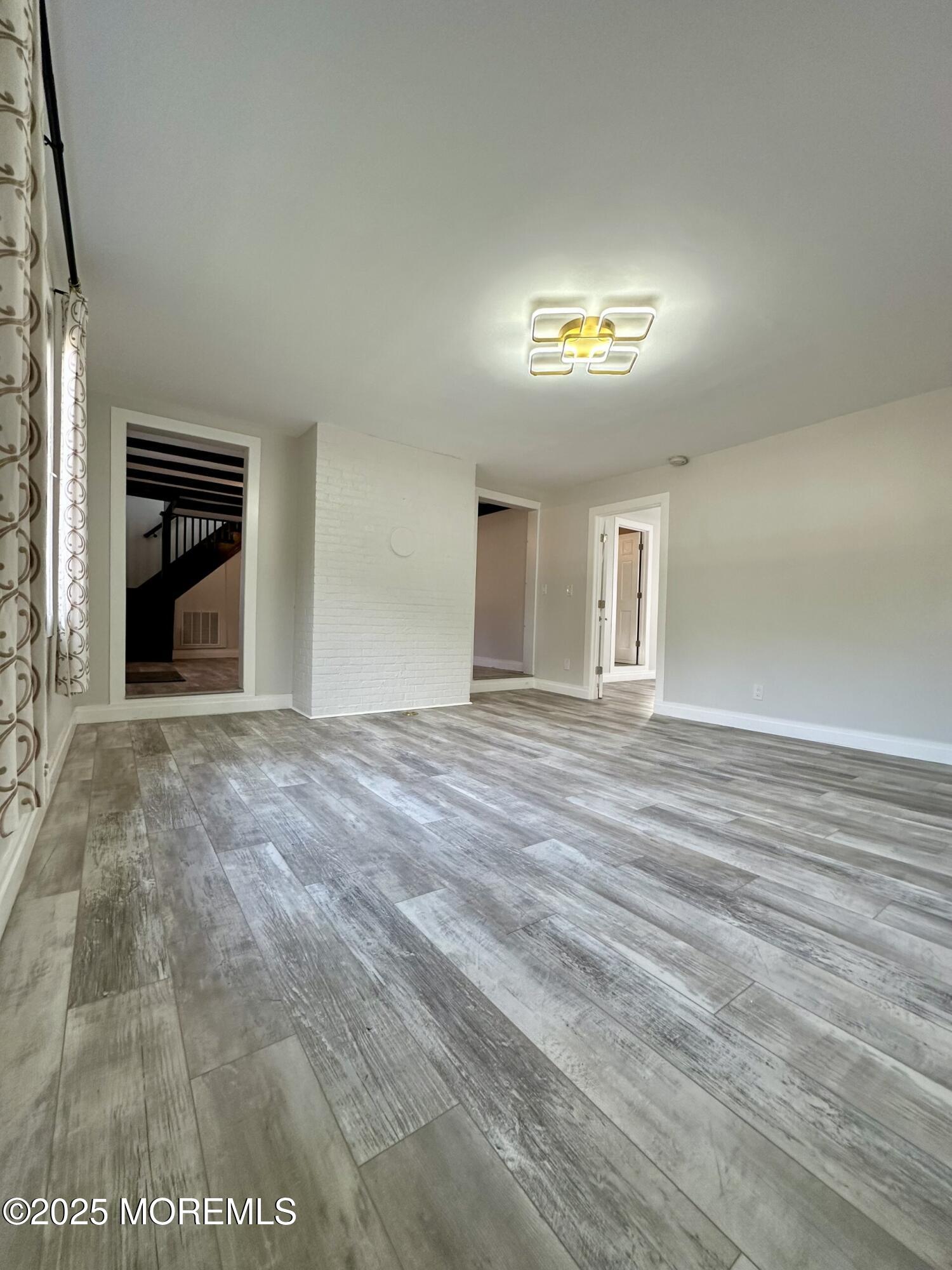72 Main Street Holmdel, NJ 07733 - Photo 23 of 45 a view of an empty room with wooden floor and a window