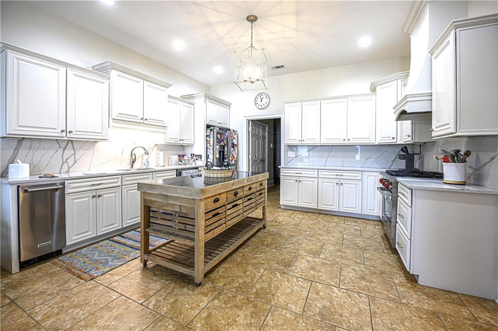 902 Quail Ridge Lane Perry, GA 31069 - Photo 13 of 25 a kitchen with kitchen island granite countertop a sink window and stainless steel appliances