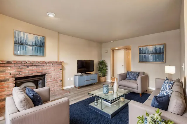 a living room with furniture a fireplace and a flat screen tv
