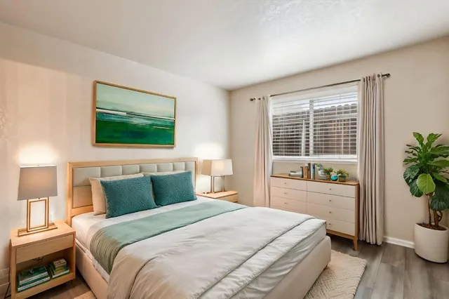 a bedroom with a large bed and a potted plant