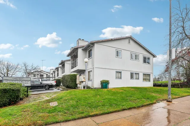 a view of a white house with a yard and table and chairs