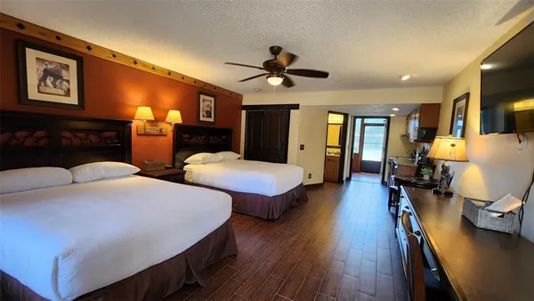 a bedroom with two beds and wooden floor