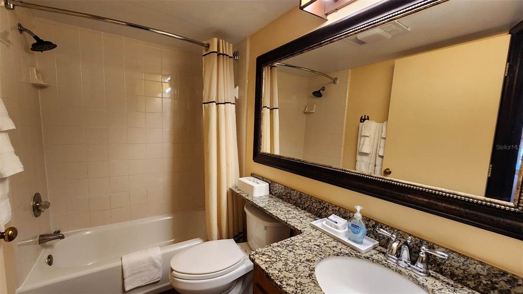 3200 River Ranch Boulevard, Unit 151 River Ranch, FL 33867 - Photo 9 of 28 a bathroom with a granite countertop sink toilet and shower