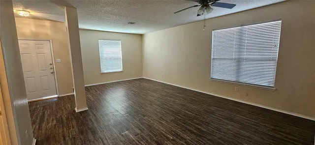 an empty room with wooden floor and a window