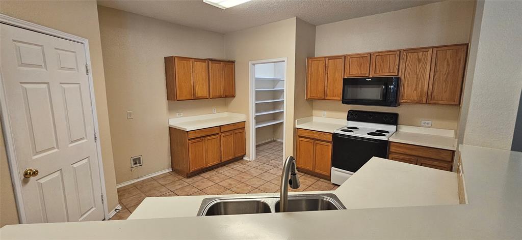2820 Deer Ridge Drive Rockwall, TX 75032 - Photo 4 of 14 a kitchen with stainless steel appliances a stove a microwave a sink and cabinets