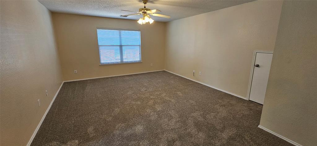2820 Deer Ridge Drive Rockwall, TX 75032 - Photo 5 of 14 an empty room with windows and chandelier fan