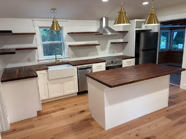 a kitchen with stainless steel appliances a kitchen island a stove and a refrigerator