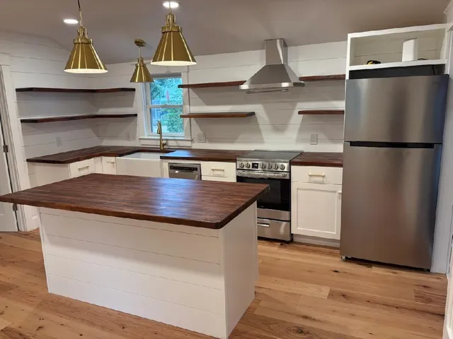 a kitchen with appliances a counter space and wooden floor