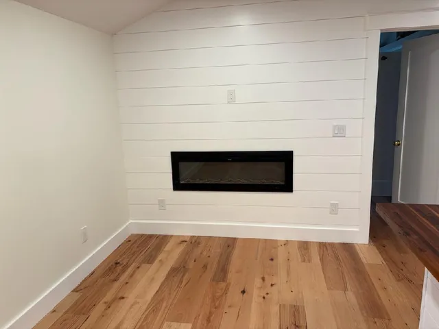 a view of a room with wooden floor and white wall
