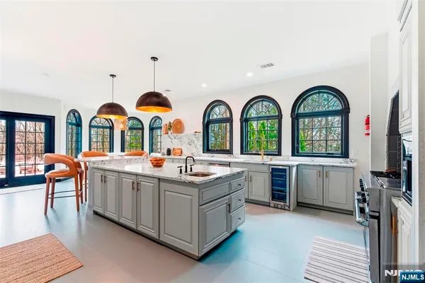 a kitchen with stainless steel appliances granite countertop a stove a sink dishwasher a refrigerator oven a dining table and chairs with wooden floor